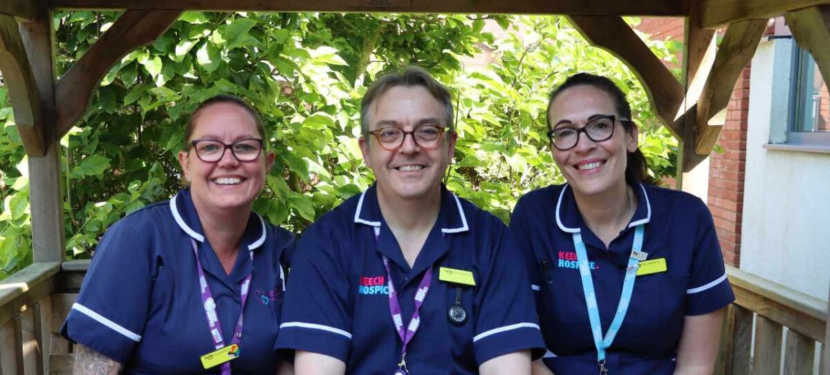 Three Nurses in uniform - Male nurse with two female nurses smiling